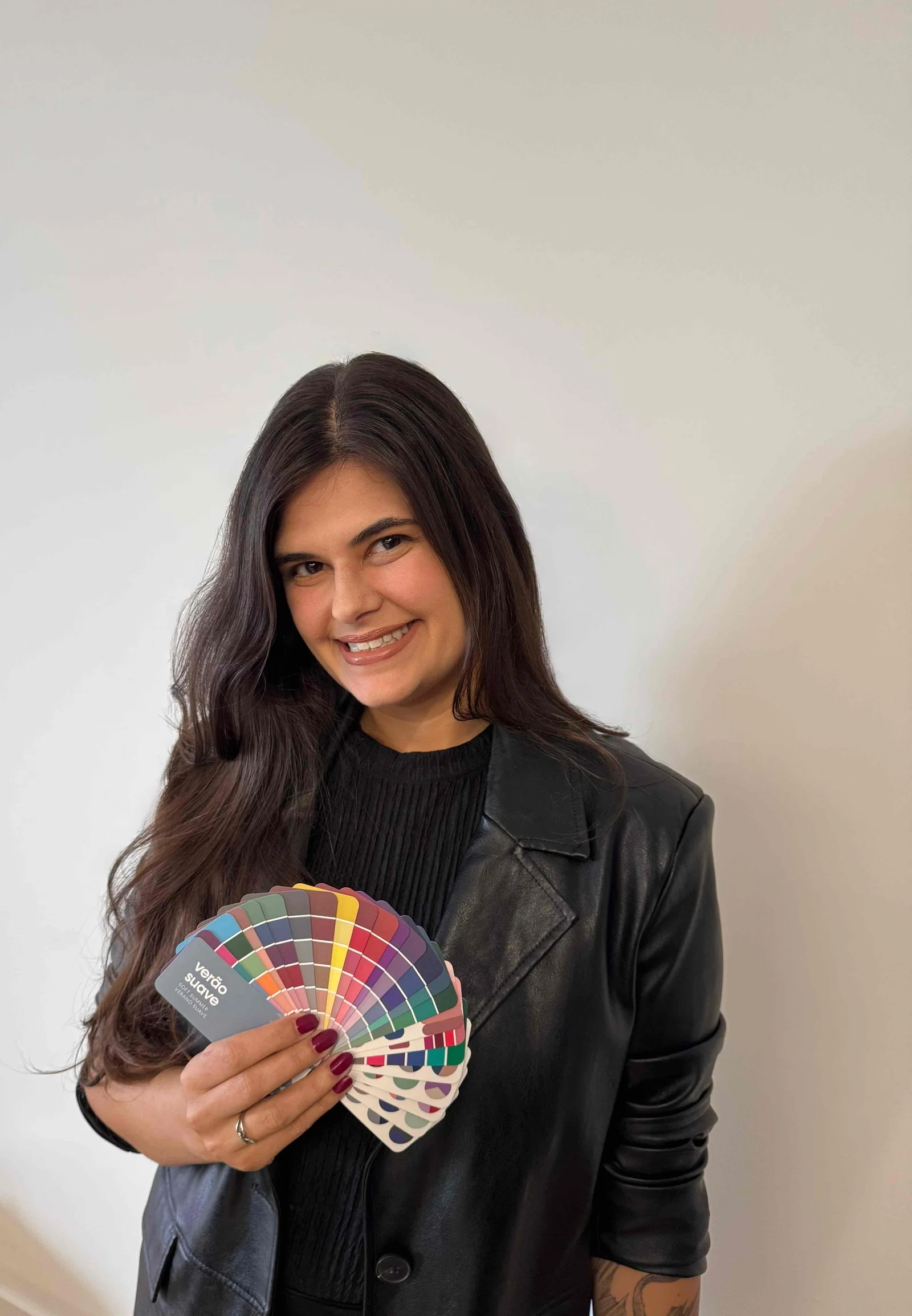 Francy Costa segurando uma paleta de cores Pantone